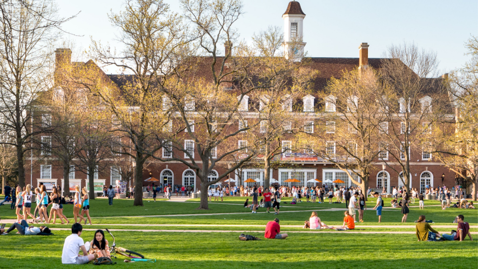 _ Students walk and sit outside on Quad lawn of University of Illinois college campus in Urbana Champaign